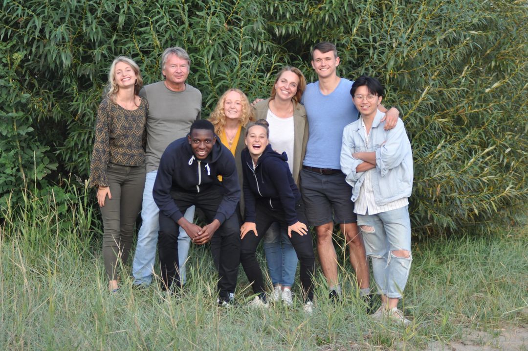 Das Team von LittleBigDreams vor grünem Gebüsch